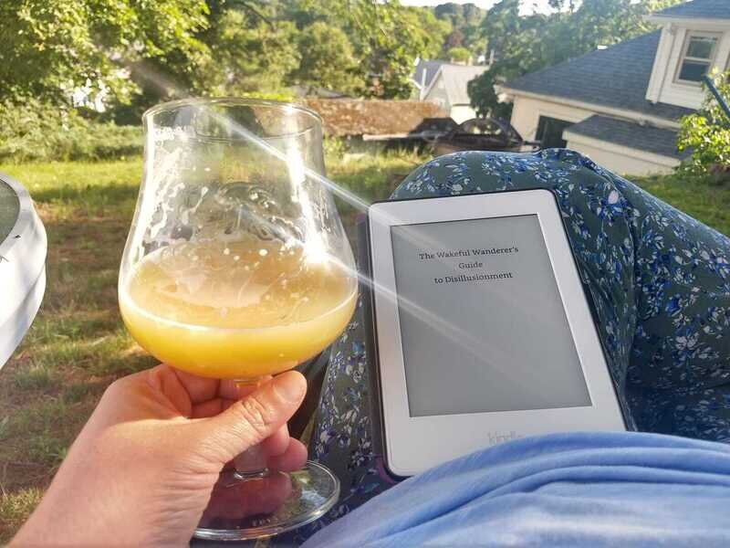 a person relaxing with a beer and a kindle